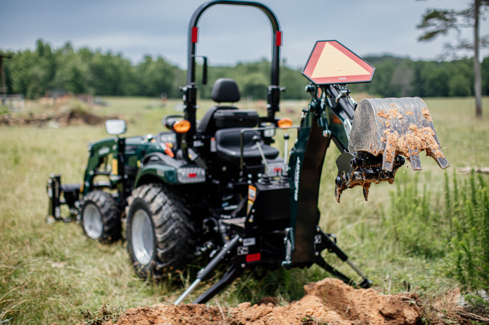 TX25H Tractor Loader Backhoe with raised bucket in field